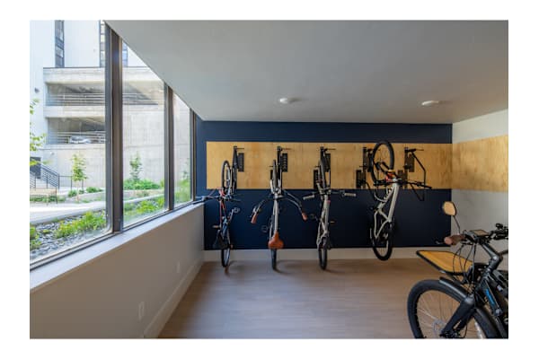 A bike room with bikes on the wall and a window.